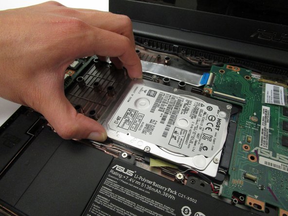 Slide the hard drive in the direction away from the connector and lift it up to remove it.