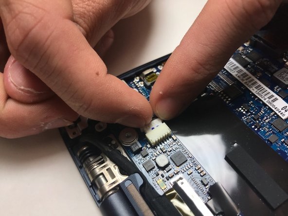 Disconnect the charging port from the motherboard by gently tugging on the plastic part of the connection.